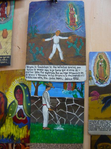 P1000748.JPG - The one at the top tells about a man who went out to chop wood and was struck by lightning but was saved by the Virgin of Guadalupe.The one at the bottom is about a man who was bitten by a scorpion while he was peeing in the garden.