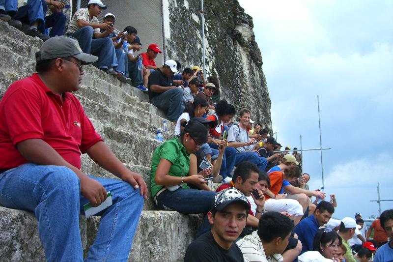 CIMG5117.JPG - It was a Sunday when we visited, so there were lots of Guatemalans at tjhe top of the largest temple. As you can see, calling on your cell phone from the middle of the jungle was a popular thing to do.